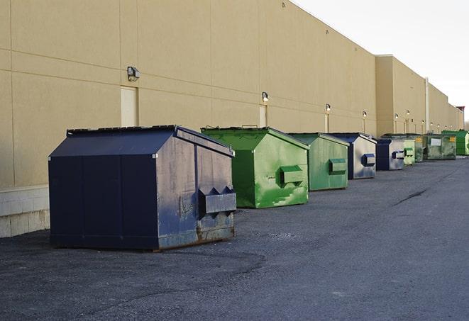 a construction worker empties a wheelbarrow of waste into the dumpster in Belfair, WA